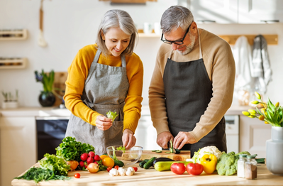 elderly couple cooking food together