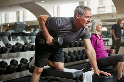 elderly man lifting weights in the gym